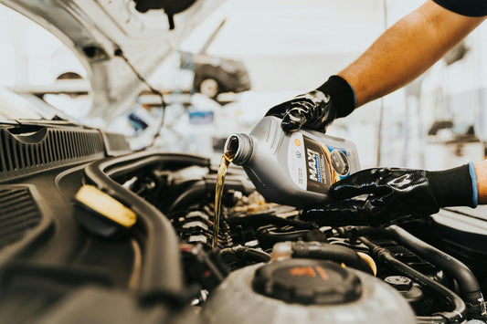 Mechanic pouring engine oil into car engine